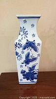 Front and side views of a vintage blue and white porcelain square vase featuring detailed floral and butterfly designs on white porcelain.