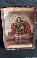 Full front view of the archangel painting showing the figure with detailed clothing and wings on canvas with frayed edges.