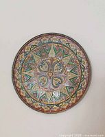 Top-down view of the round brass plate showing the detailed Byzantine mosaic enamel design with geometric and floral motifs in multiple colors.