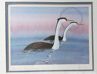 Framed art print showing two stylized water birds on water with a colorful sky background.