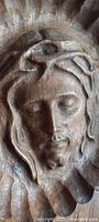 Close-up view of the carved face of Christ showing detailed facial features and crown of thorns.