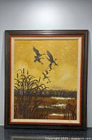 Framed vintage oil painting showing marsh, cattails, and flying ducks with yellow background.