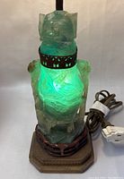 Lamp lit showing glowing green carved jade quartz body and metal fretwork collar