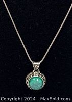 Close-up of pendant showing Ammolite stone and detailed silver setting