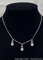 Front view of the 16-inch silver necklace with three pearl drop pendants displayed on a black bust.