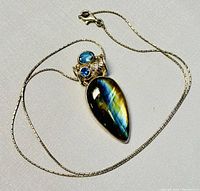 Necklace laid out on flat surface showing the full pendant and chain detail.