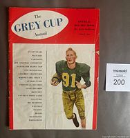 Front cover of 1956 Grey Cup Annual magazine showing Jackie Parker in a football uniform with number 91, with text and features listed on the cover.