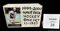 White box labeled '1999-2000 Upper Deck Hockey Base Set (1-135)' with a hockey player card image on front.