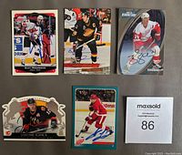 Photo of six autographed NHL hockey cards including Shanahan, Iginla, Potvin, Niedermayer, and others, arranged neatly on a flat surface.