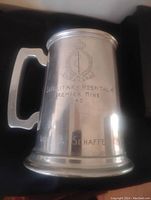 Photo of the full tankard showing the engraved crest and text.