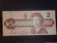 Front side of the 1986 Canadian 2 dollar bill showing Queen Elizabeth II and denomination details.