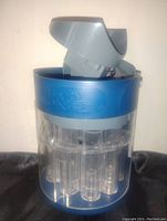 Front and upper side view of the blue and gray plastic Easy Money automatic coin sorter and roller showing the coin insertion slot and transparent tubes for coin collection.