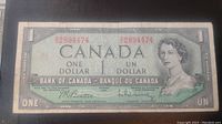 Front side of the 1954 Canadian one dollar banknote showing the portrait of Queen Elizabeth II, serial numbers, and bilingual text.
