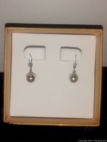 Pair of gold plated ball drop earrings, mounted on a white display card inside a box.