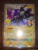 Photo of Luxray Lv. X holo foil Pokemon card with holographic background and gold border, text visible.