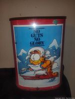 Front view of Garfield tin waste bucket showing the "No Guts No Glory" image with Garfield skiing.