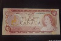 Front side of 1974 Canadian two dollar banknote showing Queen Elizabeth II and serial number.