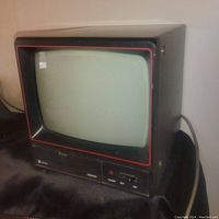 Front angle view of Vicon VM4092 retro monitor showing black casing with red trim, CRT screen, power button and label.