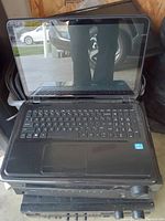 Front open view of Dell laptop showing keyboard, screen and palm rest area with Intel sticker. Condition used and screen reflective.