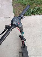 Angled top view of the scooter handlebars showing the display screen and grips.
