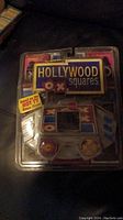 Photo of the brand new in box Hollywood Squares handheld electronic game with visible packaging and device.
