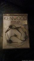 Kenwood KHS-22 headset visible in sealed plastic original packaging, showing brand, model number, and headset design.