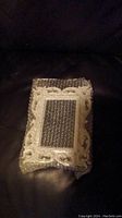 Photo of a rectangular picture frame fully wrapped in bubble wrap on a dark surface.