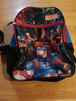 Front view of Marvel kids backpack showing multiple superhero characters and Marvel logo