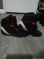 Photo shows a pair of Sedici motorcycle riding boots size 11. Black with red and white accents, high-top ankle support and lace-up and Velcro closure.