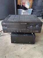 Front view of Yamaha stereo receiver showing control knobs, buttons, and headphone jack.