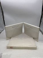 Three packs of Calvin Klein Twin flat bed sheets from The Khaki Collection in original packaging, two sealed, one slightly unsealed.