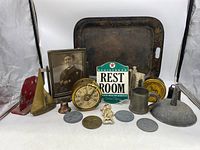 Wide view showing the assortment of various metal items and the antique picture frame.