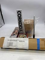 Group photo showing boxed milk frother, Corkcicle wine chiller box, coaster box, wooden block, cutlery box, and metal knife sharpener leaning on box