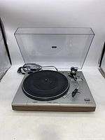 Front top view of Sanyo turntable record player with closed clear dust cover, tonearm in resting position, rubber platter mat visible