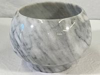 Polished marble bowl vase with a smooth rounded shape and visible natural marble veining on the exterior surface.