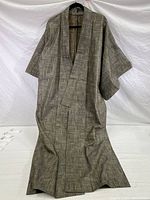 Full front view of grey-beige kimono styled robe showing length and wide sleeves with patterned fabric.
