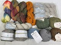 Full view of all yarn skeins laid out including various brands, blends and colors