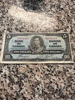 Front side of the 1927 Bank of Canada $5 bill showing portrait of King George V and serial number.