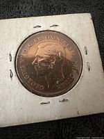 Obverse view of the 1948 British one penny coin showing King George VI profile and inscription.