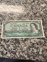 Front of a 1954 Canadian one dollar bill showing Queen Elizabeth II and bilingual text.