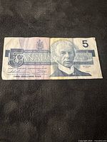 Front side of 1986 Canadian $5 bill showing Sir Wilfrid Laurier portrait with security features and denomination