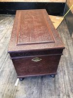 Top perspective showing embossed detailed scene and decorative border on box lid.