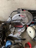 Silver Craftsman compound miter saw with clear plastic blade guard, power cord, and angle adjustment