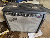 Fender Champion 110 guitar amplifier showing front panel controls and grille cloth with Fender logo