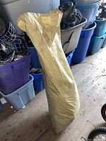 Beige canopy bag holding the folded canopy fabric and components