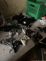 Wide shot of 7 Xbox controllers and 6 Kinect sensors scattered on table.