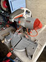 Ridgid 10-inch miter saw viewed from above, showing blade guard, handle, and base table with angle markings and miter adjustment knob.
