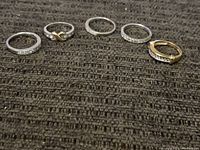 All five rings displayed on grey textured surface