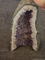 Front view of half geode showing purple crystal interior and agate border