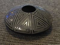 Top view of the black pottery vase showing the geometric triangular pattern.